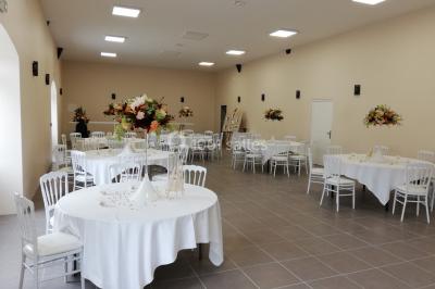 Canapé doré avec assise blanche devant un décor floral et un rideau blanc, éclairé par des appliques murales.