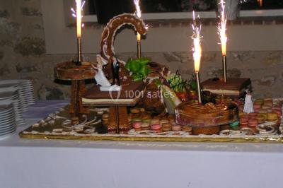 Canapé doré avec assise blanche devant un décor floral et un rideau blanc, éclairé par des appliques murales.