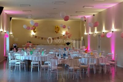 Canapé doré avec assise blanche devant un décor floral et un rideau blanc, éclairé par des appliques murales.