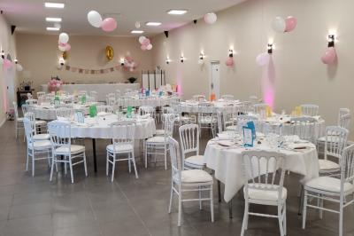 Canapé doré avec assise blanche devant un décor floral et un rideau blanc, éclairé par des appliques murales.