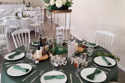 Canapé doré avec assise blanche devant un décor floral et un rideau blanc, éclairé par des appliques murales.