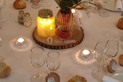 Canapé doré avec assise blanche devant un décor floral et un rideau blanc, éclairé par des appliques murales.