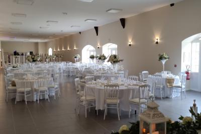 Canapé doré avec assise blanche devant un décor floral et un rideau blanc, éclairé par des appliques murales.