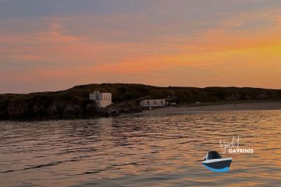 Mobilier en rotin noir avec coussins blancs sur une terrasse en bois couverte, vue sur l'extérieur urbain.