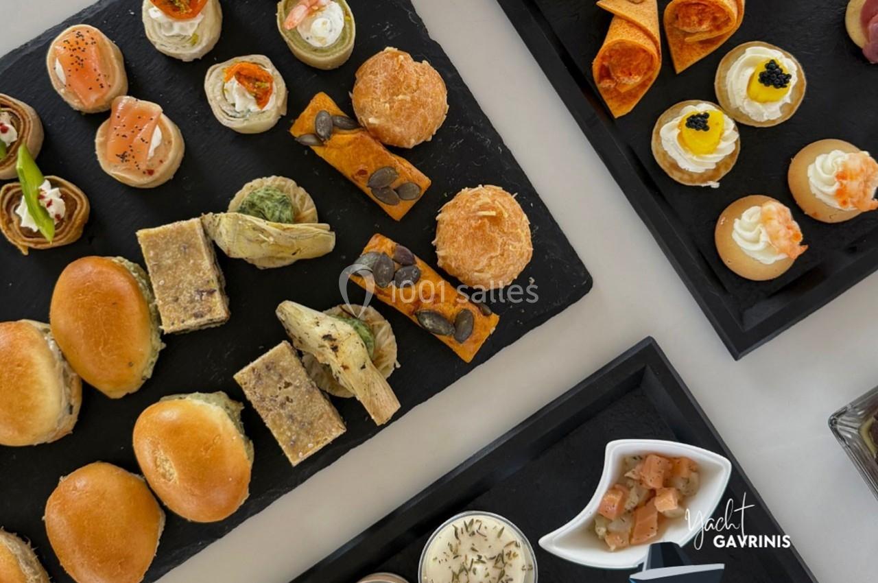 Plateaux de bouchées salées variées présentées sur des ardoises, comprenant pains, tartes et verrines.