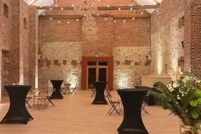 Comptoir noir devant un mur rouge décoré de motifs floraux, éclairé par des suspensions dans un espace à la décoration…