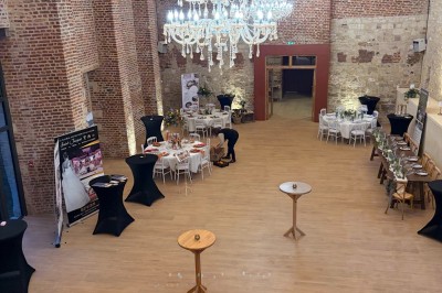 Comptoir noir devant un mur rouge décoré de motifs floraux, éclairé par des suspensions dans un espace à la décoration…