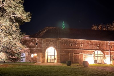 Comptoir noir devant un mur rouge décoré de motifs floraux, éclairé par des suspensions dans un espace à la décoration…