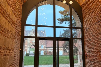 Comptoir noir devant un mur rouge décoré de motifs floraux, éclairé par des suspensions dans un espace à la décoration…