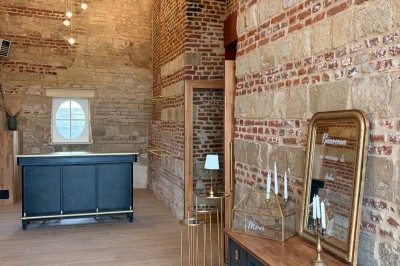 Comptoir noir devant un mur rouge décoré de motifs floraux, éclairé par des suspensions dans un espace à la décoration…