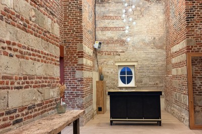 Comptoir noir devant un mur rouge décoré de motifs floraux, éclairé par des suspensions dans un espace à la décoration…