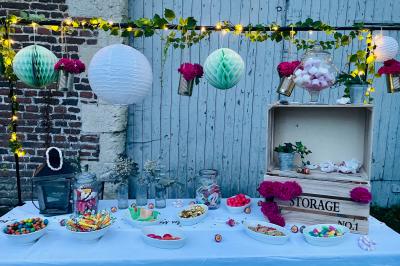 Miniature Bar à bonbons Pièce rustique avec murs en pierre, plafond en bois, réservoir métallique rouge et mobilier simple.