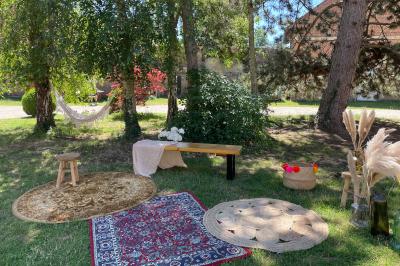 Miniature Cour intérieur avec espace cosy Pièce rustique avec murs en pierre, plafond en bois, réservoir métallique rouge et mobilier simple.