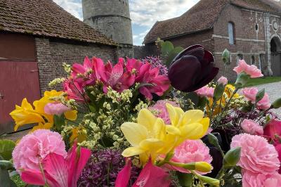 Miniature Cour intérieure du Château Pièce rustique avec murs en pierre, plafond en bois, réservoir métallique rouge et mobilier simple.
