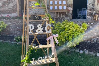 Miniature Entrée décorée de la Bergerie Pièce rustique avec murs en pierre, plafond en bois, réservoir métallique rouge et mobilier simple.