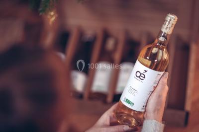 Un couple en tenue de mariage s'embrasse sous un voile, tenant un bouquet de fleurs.