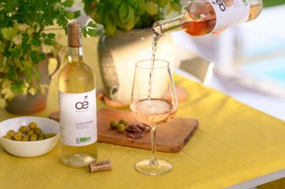 Un couple en tenue de mariage s'embrasse sous un voile, tenant un bouquet de fleurs.