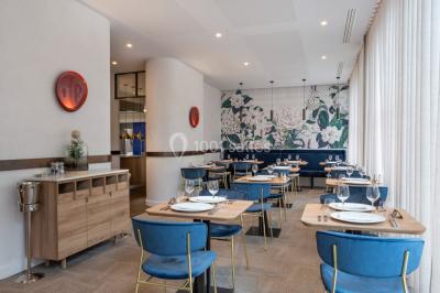 Buffet de petit-déjeuner avec viennoiseries, pain, fruits et fontaine de chocolat dans une salle décorée de motifs tropicaux.