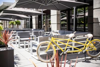Buffet de petit-déjeuner avec viennoiseries, pain, fruits et fontaine de chocolat dans une salle décorée de motifs tropicaux.