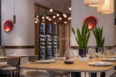 Buffet de petit-déjeuner avec viennoiseries, pain, fruits et fontaine de chocolat dans une salle décorée de motifs tropicaux.