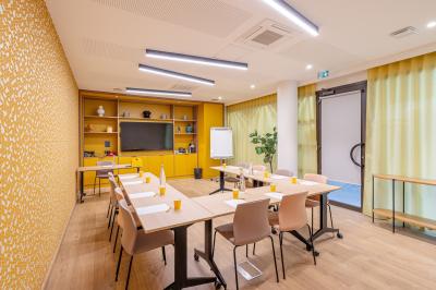Buffet de petit-déjeuner avec viennoiseries, pain, fruits et fontaine de chocolat dans une salle décorée de motifs tropicaux.