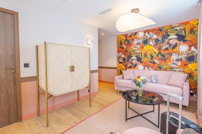 Buffet de petit-déjeuner avec viennoiseries, pain, fruits et fontaine de chocolat dans une salle décorée de motifs tropicaux.