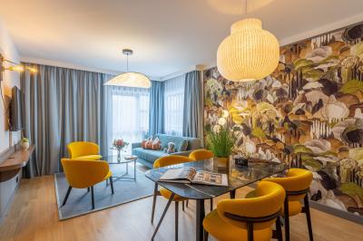 Buffet de petit-déjeuner avec viennoiseries, pain, fruits et fontaine de chocolat dans une salle décorée de motifs tropicaux.