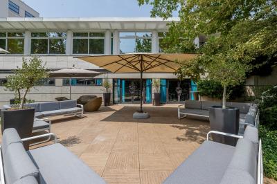 Buffet de petit-déjeuner avec viennoiseries, pain, fruits et fontaine de chocolat dans une salle décorée de motifs tropicaux.