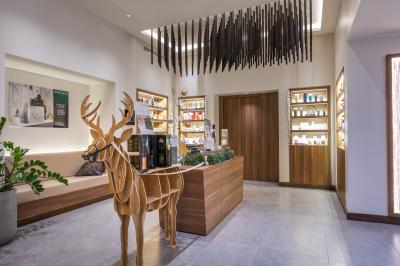 Buffet de petit-déjeuner avec viennoiseries, pain, fruits et fontaine de chocolat dans une salle décorée de motifs tropicaux.