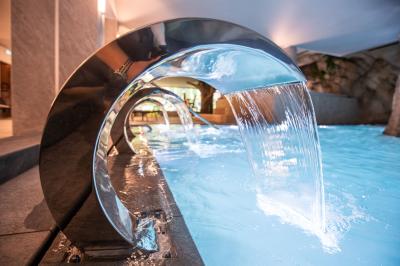 Buffet de petit-déjeuner avec viennoiseries, pain, fruits et fontaine de chocolat dans une salle décorée de motifs tropicaux.