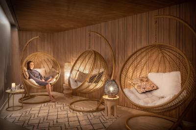 Buffet de petit-déjeuner avec viennoiseries, pain, fruits et fontaine de chocolat dans une salle décorée de motifs tropicaux.