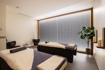 Buffet de petit-déjeuner avec viennoiseries, pain, fruits et fontaine de chocolat dans une salle décorée de motifs tropicaux.