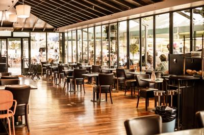 Buffet de petit-déjeuner avec viennoiseries, pain, fruits et fontaine de chocolat dans une salle décorée de motifs tropicaux.