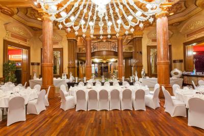 Buffet de petit-déjeuner avec viennoiseries, pain, fruits et fontaine de chocolat dans une salle décorée de motifs tropicaux.
