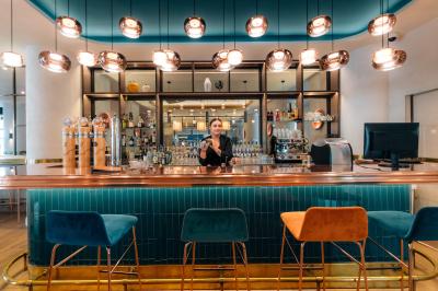 Buffet de petit-déjeuner avec viennoiseries, pain, fruits et fontaine de chocolat dans une salle décorée de motifs tropicaux.