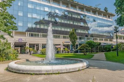 Buffet de petit-déjeuner avec viennoiseries, pain, fruits et fontaine de chocolat dans une salle décorée de motifs tropicaux.
