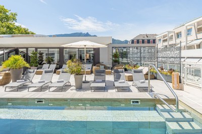 Buffet de petit-déjeuner avec viennoiseries, pain, fruits et fontaine de chocolat dans une salle décorée de motifs tropicaux.
