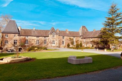 Structure en verre illuminée par des lumières violettes au crépuscule, avec un ciel dégagé en arrière-plan.