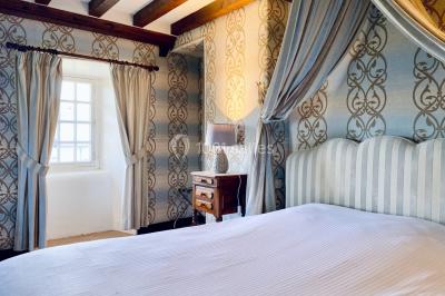 Structure en verre illuminée par des lumières violettes au crépuscule, avec un ciel dégagé en arrière-plan.