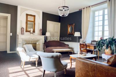 Structure en verre illuminée par des lumières violettes au crépuscule, avec un ciel dégagé en arrière-plan.