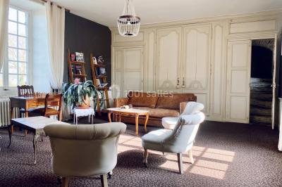 Structure en verre illuminée par des lumières violettes au crépuscule, avec un ciel dégagé en arrière-plan.