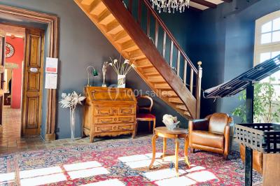 Structure en verre illuminée par des lumières violettes au crépuscule, avec un ciel dégagé en arrière-plan.