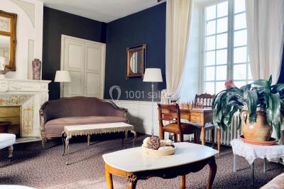 Structure en verre illuminée par des lumières violettes au crépuscule, avec un ciel dégagé en arrière-plan.