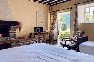 Structure en verre illuminée par des lumières violettes au crépuscule, avec un ciel dégagé en arrière-plan.