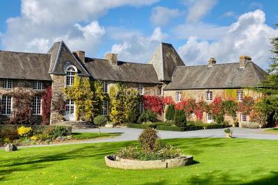 Structure en verre illuminée par des lumières violettes au crépuscule, avec un ciel dégagé en arrière-plan.