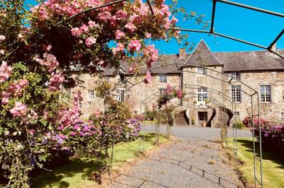 Structure en verre illuminée par des lumières violettes au crépuscule, avec un ciel dégagé en arrière-plan.