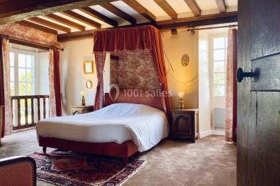 Structure en verre illuminée par des lumières violettes au crépuscule, avec un ciel dégagé en arrière-plan.