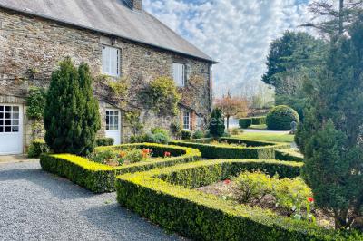 Structure en verre illuminée par des lumières violettes au crépuscule, avec un ciel dégagé en arrière-plan.