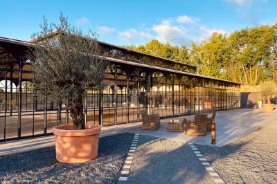Structure en verre illuminée par des lumières violettes au crépuscule, avec un ciel dégagé en arrière-plan.