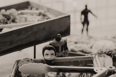 Centre de table avec bougies torsadées, fleurs colorées et nappe orange, entouré de verres et couverts.